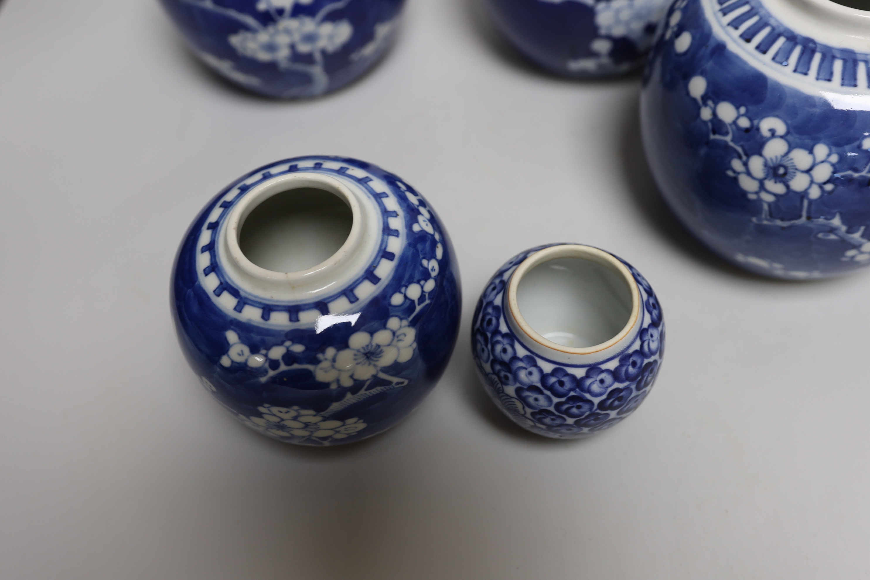 Five Chinese blue and white prunus ginger jars, one with cover- 15cm high and another jar